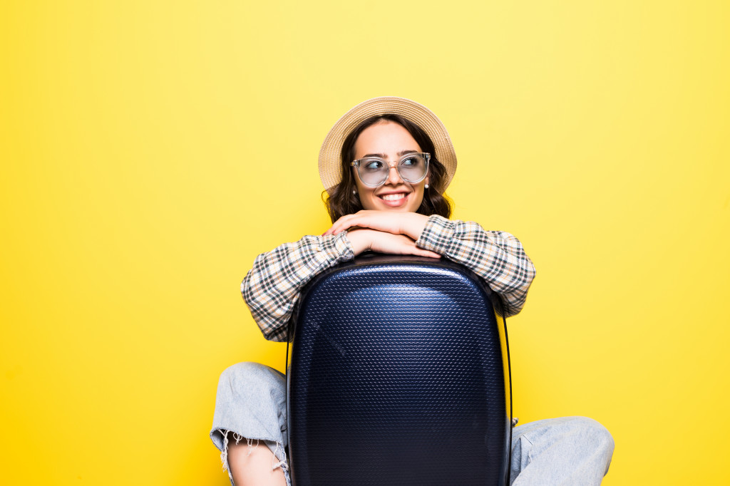 travel-and-lifestyle-concept-portrait-of-a-girl-in-straw-hat-and-sunglasses-with-suitcase-looking-isolated