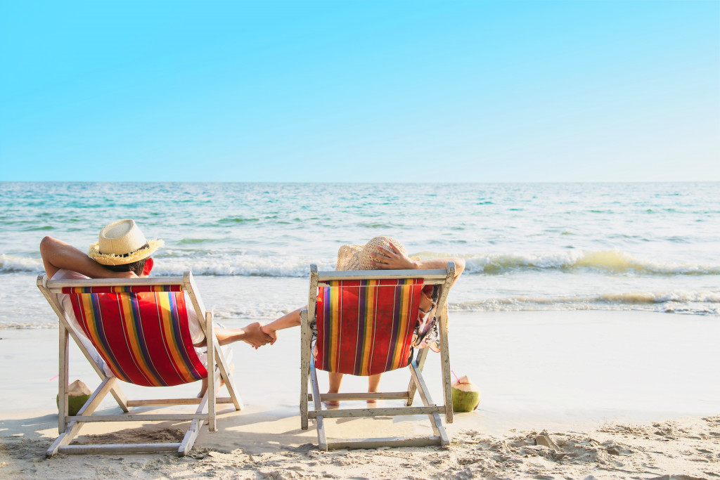 relax-couple-lay-down-on-beach-chiar-with-sea-wave-man-and-woman-have-vacation-at-sea-nature-concept